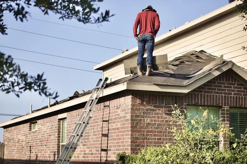 Professional roofer working on a residential roof in Show Place